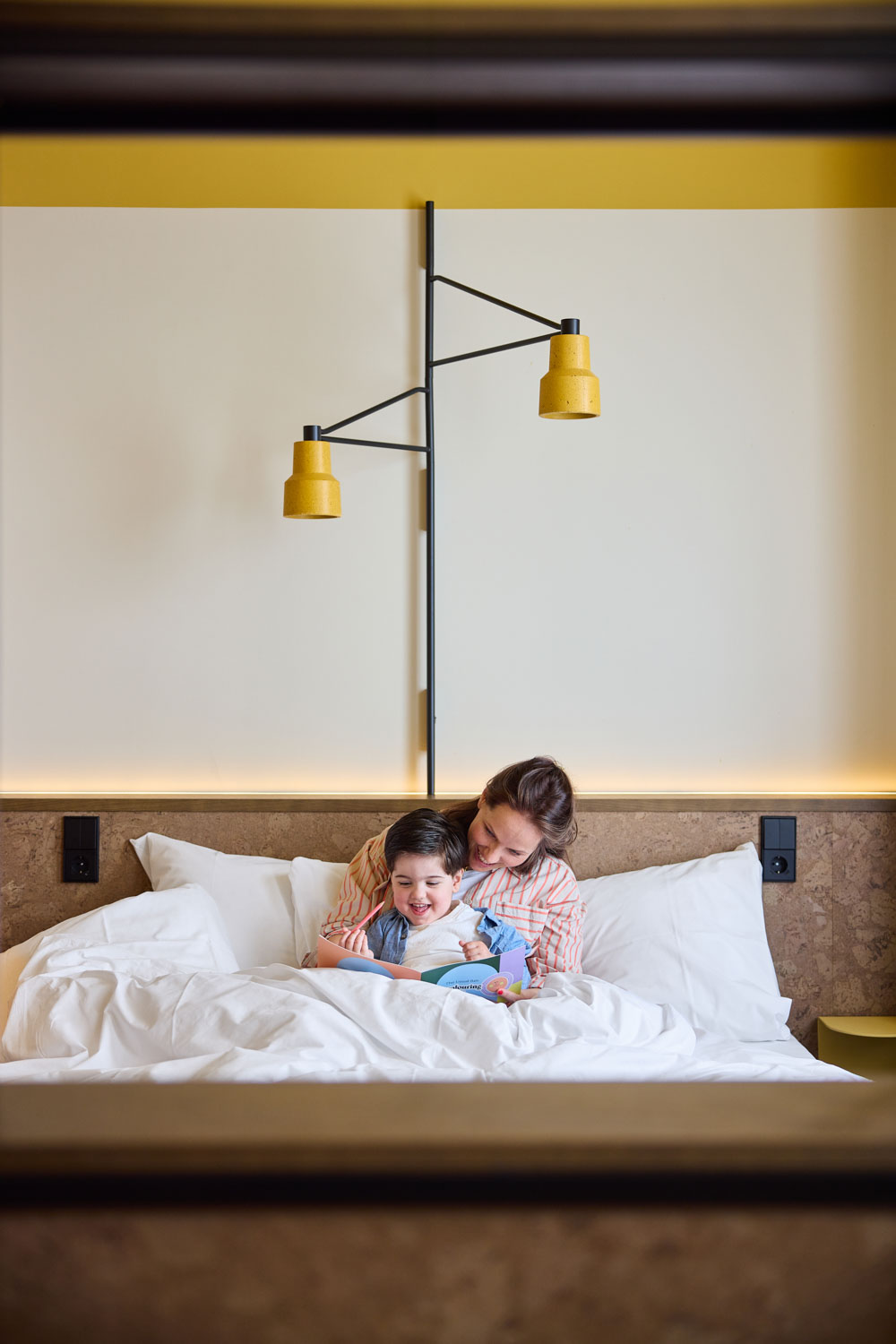Mother and young son snuggling in bed in The Studio